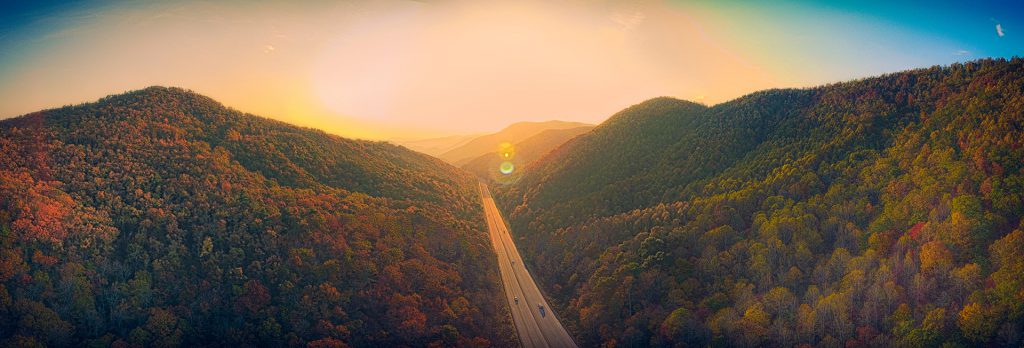 Decorative. Aerial of highway leading into the Blue Ridge Mountains at sunset.