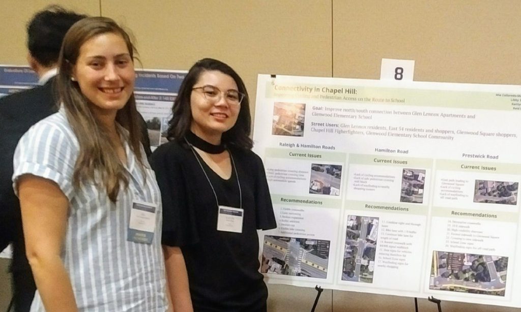Two women standing in front of research posters.